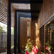 Wood slats filter the light in this outdoor architecture, courtyard, daylighting, facade, home, house, interior design, lighting, window, wood, black, brown