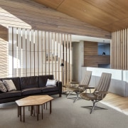 This living space sits at the centre of architecture, ceiling, daylighting, floor, flooring, furniture, house, interior design, living room, real estate, wall, wood, wood flooring, white, brown, gray