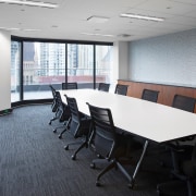 This long meeting room features expansive city views conference hall, floor, flooring, furniture, interior design, office, real estate, table, gray, white, black