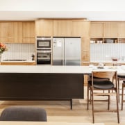 Wood cabinets and an elevated island help to cabinetry, countertop, cuisine classique, furniture, interior design, kitchen, product design, table, white