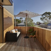 A wood deck and balustrade create a warm, backyard, balcony, deck, home, house, outdoor structure, property, real estate, roof, wood, brown
