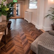 Herringbone patterns can give homes and commercial spaces floor, flooring, hardwood, home, interior design, laminate flooring, living room, real estate, tile, wood, wood flooring, brown, gray