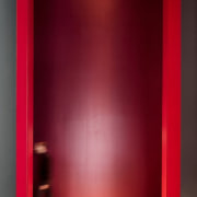 This massive doorway is certainly imposing - This door, floor, interior design, light, lighting, red, wall, red
