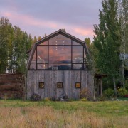 This large window looks out to the distant barn, cottage, farm, farmhouse, grass, home, house, hut, land lot, landscape, property, real estate, rural area, shack, shed, tree, brown