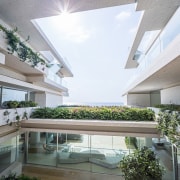 This large courtyard opens up to the sea apartment, architecture, balcony, condominium, courtyard, daylighting, daytime, estate, facade, home, house, interior design, mixed use, property, real estate, residential area, roof, window, white, gray