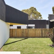 There's ample yard space in between the different architecture, backyard, courtyard, facade, fence, home, home fencing, house, outdoor structure, property, real estate, residential area, siding, yard