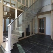 A metal staircase leads you up to the architecture, baluster, daylighting, floor, flooring, glass, handrail, interior design, lobby, stairs, structure, tile, gray, black