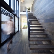 This wood staircase floats up to the second apartment, architecture, daylighting, floor, flooring, hardwood, home, house, interior design, loft, real estate, stairs, wood, wood flooring, black, gray