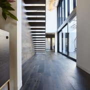 This wood floor runs along the floor and architecture, daylighting, floor, flooring, hardwood, home, house, interior design, laminate flooring, property, real estate, tile, wood, wood flooring, gray, black