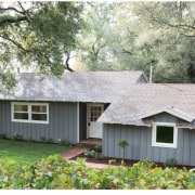 The farmhouse sits in a leafy surrounding - cottage, estate, farmhouse, home, house, landscape, property, real estate, roof, siding, tree, yard, white