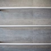 Heated towel rails provide an industrial touch in wood, gray