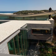 You can glimpse the beach nearby - You architecture, home, house, property, real estate, roof, black