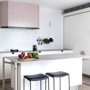 A light pink rangehood provides a quiet feature white