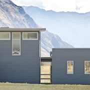 exterior of house at rear, otago mountains in architecture, building, cottage, elevation, facade, farmhouse, home, house, hut, property, real estate, siding, sky, window, white