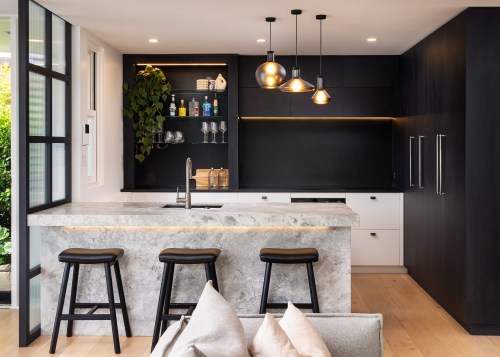 Concealed lighting accentuates the kitchen's various feature materials. 