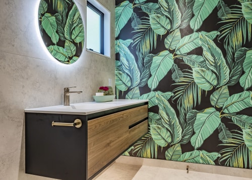 The cantilevered wood vanity complements the dramatic tropical 