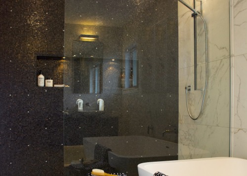 Black mosaics in the shower create contrast, and architecture, bathroom, bathroom accessory, building, ceiling, floor, flooring, furniture, glass, interior design, lighting, marble, plumbing fixture, property, room, shower, tap, tile, wall, black
