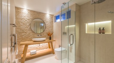 淋浴空间通过玻璃隔开，实用又简单，内嵌式的置物太配上暖色的灯光，感觉很温暖。 bathroom, home, interior design, real estate, room, brown, gray