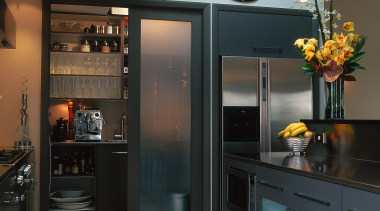 The view of a kitchen with an open cabinetry, countertop, home appliance, interior design, kitchen, black, gray