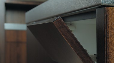 The detail of a flip down flap on furniture, product design, wood, black