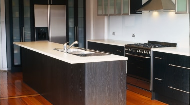 Kitchen with dark grey toned cabinetry, with glass cabinetry, countertop, cuisine classique, floor, flooring, hardwood, interior design, kitchen, laminate flooring, wood, wood flooring, black