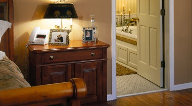 View of the bedroom by the bathroom - bedroom, door, floor, flooring, furniture, hardwood, home, interior design, room, suite, wood, wood flooring, brown, black