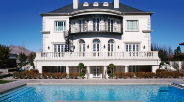 Overall exterior view of a large white house building, estate, facade, home, house, mansion, property, real estate, resort, resort town, sky, swimming pool, villa, blue