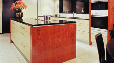 Contemporary kitchen with black granite benchtops, rosewood veneer cabinetry, countertop, cuisine classique, floor, flooring, furniture, interior design, kitchen, room, red, white