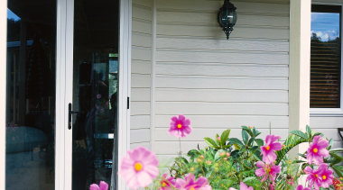 Exterior of home with cream coloured weatherboards and backyard, floristry, flower, garden, home, house, outdoor structure, plant, porch, real estate, siding, spring, window, yard