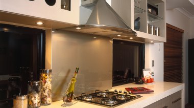 A view of a kitchen, wooden flooring, cream countertop, cuisine classique, interior design, kitchen, room, under cabinet lighting, gray, black