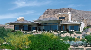 An exterior view of a large concrete and cottage, elevation, estate, home, house, mansion, mountain, property, real estate, roof, sky, villa, teal