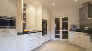 Kitchen with reflective black granite benchtops, light coloured cabinetry, countertop, cuisine classique, floor, flooring, home appliance, interior design, kitchen, property, real estate, room, orange