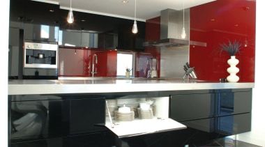 Kitchen with lacquered black cabinetry and bright red architecture, countertop, floor, flooring, furniture, interior design, kitchen, living room, product design, table, white, black