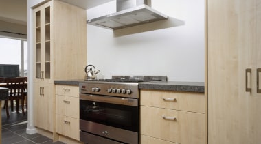 Kitchen with light tan cabinetry, stainless steel oven cabinetry, countertop, cuisine classique, floor, furniture, home appliance, interior design, kitchen, room, gray