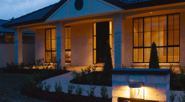 Front exterior entranceway of home, showing night lighting. architecture, building, cloud, cottage, estate, evening, facade, home, house, lighting, real estate, reflection, residential area, roof, siding, sky, window, black, teal