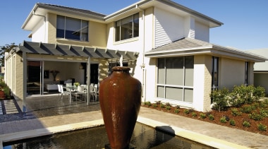 A view of the large water feature with building, facade, home, house, property, real estate, residential area, siding, window, brown