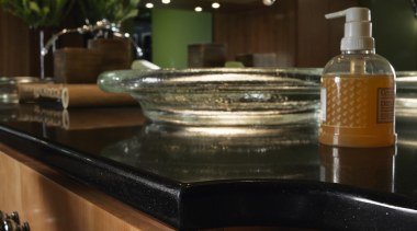 A view of a bathroom, wooden cabinetry, marble countertop, furniture, glass, kitchen, table, brown, black