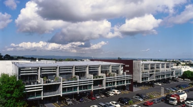 A view of the entire complex. - A building, car, city, cloud, daytime, metropolis, metropolitan area, mixed use, parking lot, plant, real estate, residential area, road, sky, suburb, tree, urban area, gray, black