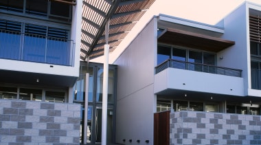 An exterior view of an entrance way with architecture, building, commercial building, condominium, corporate headquarters, daylighting, daytime, facade, headquarters, house, property, real estate, residential area, sky, window, blue, white