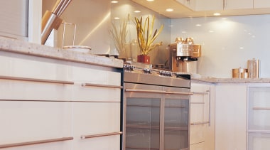 Kitchen with light coloured cabinetry, stainless steel oven cabinetry, chest of drawers, countertop, cuisine classique, drawer, floor, furniture, hardwood, interior design, kitchen, room, wood, gray