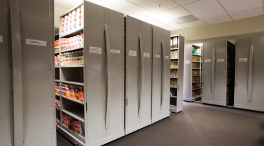 A view of some shelving storage systems. - floor, flooring, institution, shelf, shelving, gray