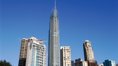 View of tall apartment buildings. - View of building, city, cityscape, condominium, corporate headquarters, daytime, downtown, landmark, metropolis, metropolitan area, mixed use, sky, skyline, skyscraper, tower, tower block, urban area, blue
