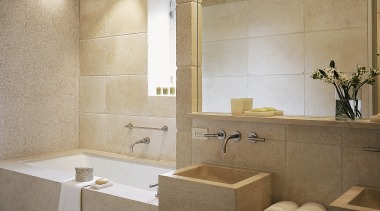 View of this bathroom featuring two seater bathtub, architecture, bathroom, ceiling, floor, flooring, interior design, plumbing fixture, room, sink, tile, wall, gray, brown