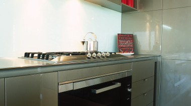 view of this kitchen featuring miele five burner architecture, cabinetry, countertop, floor, home appliance, interior design, kitchen, major appliance, room, sink, brown, black