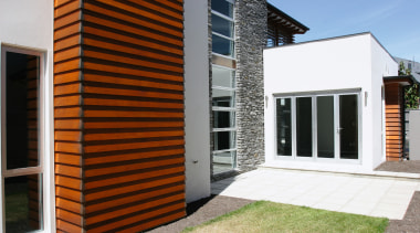 Exterior of home showing cedar weatherboards, schist column architecture, building, door, elevation, facade, home, house, property, real estate, residential area, siding, window, white
