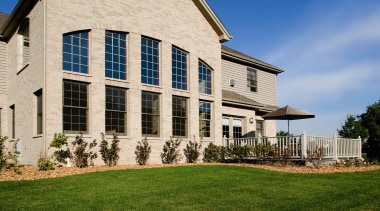 A view of some windows and doors by building, cottage, estate, facade, farmhouse, grass, home, house, lawn, mansion, property, real estate, residential area, siding, window, gray, brown