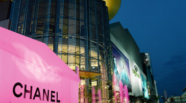 An exterior view of a shopping mall. - architecture, building, city, cityscape, downtown, landmark, light, lighting, metropolis, metropolitan area, mixed use, night, reflection, sky, structure, tourist attraction, blue