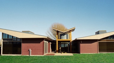 Exterior view of this building, low sloped pitched architecture, cottage, elevation, facade, farmhouse, home, house, property, real estate, residential area, roof, siding, teal