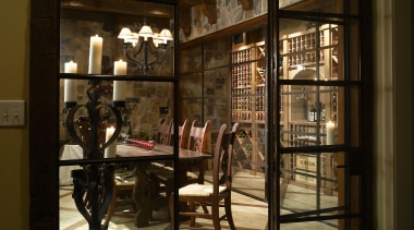 View of wine cellar with stone floor and door, furniture, interior design, lobby, window, brown