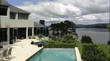 A view of some swimming pool grates. - arecales, condominium, estate, home, hotel, house, leisure, palm tree, property, real estate, resort, sea, sky, swimming pool, vacation, villa, water, gray